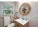 Cozy bathroom features a wood vanity, decorative mirror and sunny window at 617 26Th W St, Bradenton, FL 34205