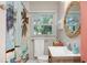 Bright bathroom featuring a stylish vanity, palm tree shower curtain, and a round mirror at 617 26Th W St, Bradenton, FL 34205