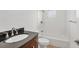 Bathroom featuring a dark vanity, brushed nickel fixtures and shower with white subway tile at 6637 Bowline Dr, Sarasota, FL 34231