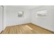 Bright bedroom featuring wood floors, white walls, and natural light from two windows at 6637 Bowline Dr, Sarasota, FL 34231