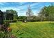 Expansive backyard with lush green grass, tropical plants, and serene pond views, creating a tranquil outdoor space at 7137 Orchid Island Pl, Bradenton, FL 34202