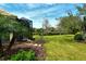 Inviting backyard with a screened lanai, manicured lawn, and peaceful views of a scenic pond, perfect for outdoor living at 7137 Orchid Island Pl, Bradenton, FL 34202