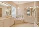 Bright bathroom featuring dual sinks, tiled floor and walls, and an appealing garden tub at 7137 Orchid Island Pl, Bradenton, FL 34202