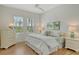 Bright bedroom featuring two large windows with shutters, light walls and ceiling fan, and hardwood floors at 7137 Orchid Island Pl, Bradenton, FL 34202