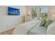 Bedroom with large bed, two windows with shutters, and a wall mounted TV with bright outdoor view at 7137 Orchid Island Pl, Bradenton, FL 34202