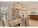 Formal dining room with decorative light fixture, wood table, and neutral color palette at 7137 Orchid Island Pl, Bradenton, FL 34202