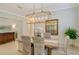 Formal dining room with decorative light fixture, wood table, and neutral color palette at 7137 Orchid Island Pl, Bradenton, FL 34202