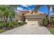 Well-maintained home with lush landscaping, brick-paved driveway, and a two-car garage, exuding curb appeal at 7137 Orchid Island Pl, Bradenton, FL 34202