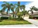 Charming home with well-manicured lawn, tropical landscaping, and a paved driveway leading to a two-car garage at 7137 Orchid Island Pl, Bradenton, FL 34202
