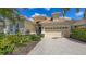 Beautiful home with a well-maintained lawn, lush landscaping, and a paved driveway leading to a two-car garage at 7137 Orchid Island Pl, Bradenton, FL 34202