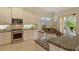 Well-lit kitchen with stainless steel appliances, granite counters, white cabinets, and outdoor views at 7137 Orchid Island Pl, Bradenton, FL 34202