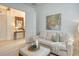 Living room featuring sectional sofa, hardwood floors, light walls, and doorway to hallway with mirror at 7137 Orchid Island Pl, Bradenton, FL 34202
