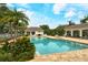 Community pool with covered cabanas, seating areas, and lush tropical landscaping, ideal for outdoor entertaining at 7137 Orchid Island Pl, Bradenton, FL 34202