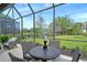 Relaxing screened lanai showcasing serene lake views and a cozy outdoor dining set at 7137 Orchid Island Pl, Bradenton, FL 34202