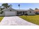 Single-story home with manicured front yard and a paved driveway leading to a garage at 7307 14Th W Ave, Bradenton, FL 34209