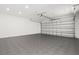 Spacious garage with a gray tile floor and a metal roll-up door at 7307 14Th W Ave, Bradenton, FL 34209