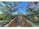 A wooden boardwalk leads towards a scenic waterfront view framed by lush greenery, offering a tranquil escape at 7615 4Th W Ave # 7615, Bradenton, FL 34209