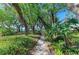 A tranquil, lush path surrounded by greenery invites exploration, showcasing the property's serene natural beauty and landscape at 7615 4Th W Ave # 7615, Bradenton, FL 34209