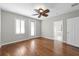 Bedroom with hardwood flooring, a ceiling fan, and access to a bathroom at 7665 Bergamo Ave, Sarasota, FL 34238