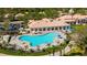 Aerial view of a community pool area with ample seating, umbrellas, and well-maintained landscaping at 7665 Bergamo Ave, Sarasota, FL 34238