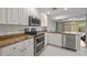 The kitchen has stainless steel appliances, granite countertops, white cabinets, and access to the backyard at 7665 Bergamo Ave, Sarasota, FL 34238