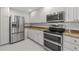 Close up of the kitchen featuring stainless steel appliances, white cabinets, and granite countertops at 7665 Bergamo Ave, Sarasota, FL 34238