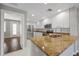 Stylish kitchen featuring stainless steel appliances, granite countertops, and white cabinets, open to the living space at 7665 Bergamo Ave, Sarasota, FL 34238
