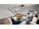 Inviting living room with hardwood floors, a ceiling fan, and an open view into the dining area and kitchen at 7665 Bergamo Ave, Sarasota, FL 34238