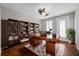 Bright home office with hardwood floors, built-in bookshelves, and a modern desk setup at 7665 Bergamo Ave, Sarasota, FL 34238