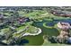 Expansive aerial view of a lush golf course community with lake views and beautiful red-roofed buildings at 7782 Club Ln, Sarasota, FL 34238