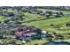 Scenic aerial view of a golf course community with a red-roofed clubhouse, surrounded by mature trees and greenery at 7782 Club Ln, Sarasota, FL 34238