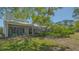 Picturesque backyard featuring a covered patio, privacy landscaping, and beautiful green lawn at 7782 Club Ln, Sarasota, FL 34238