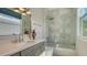 Bright bathroom features an updated vanity, glass shower and tub combination, and natural light at 7782 Club Ln, Sarasota, FL 34238