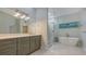 A luxurious bathroom featuring a soaking tub and glass shower with modern fixtures at 7782 Club Ln, Sarasota, FL 34238