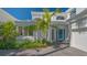 Stunning home featuring a bright, blue door with tropical landscaping at 7782 Club Ln, Sarasota, FL 34238