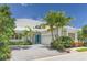 Inviting two-story home with well-manicured landscaping and a blue door, offering an attractive curb appeal at 7782 Club Ln, Sarasota, FL 34238