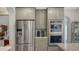 Bright modern kitchen features gray cabinets, stainless steel appliances, and views to formal dining at 7782 Club Ln, Sarasota, FL 34238