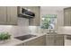 Modern kitchen with stainless steel appliances, elegant cabinetry, and a window overlooking the yard at 7782 Club Ln, Sarasota, FL 34238