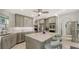 Open kitchen features stainless steel appliances, a center island with bar stools, and tile flooring at 7782 Club Ln, Sarasota, FL 34238