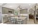 Stylish kitchen with gray cabinets, white countertops, stainless appliances, island with bar seating, and views to formal dining at 7782 Club Ln, Sarasota, FL 34238