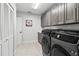 Well-organized laundry room with modern washer and dryer and plenty of cabinet space at 7782 Club Ln, Sarasota, FL 34238