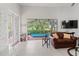 Bright living room featuring a seamless indoor-outdoor flow to a screened patio with a pool at 7782 Club Ln, Sarasota, FL 34238