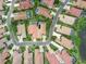 Aerial view of the community, showcasing tile roofs, mature trees, and lush landscaping at 8024 Via Fiore, Sarasota, FL 34238