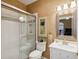 Bathroom featuring tiled shower with glass door, vanity with sink, mirror, and attractive wallpaper at 8024 Via Fiore, Sarasota, FL 34238