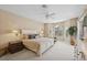 Bright bedroom with plush carpet, neutral walls, and large windows with a view of the screened-in pool at 8024 Via Fiore, Sarasota, FL 34238