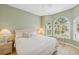 Light-filled bedroom with neutral walls, white furniture, arched windows, and bright, natural light at 8024 Via Fiore, Sarasota, FL 34238