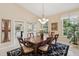 Elegant dining room featuring a chandelier, hardwood table, and a view to the kitchen and the outdoors at 8024 Via Fiore, Sarasota, FL 34238