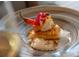 Gourmet dish of fish and rice, garnished with flower petals and a red pepper at 8024 Via Fiore, Sarasota, FL 34238
