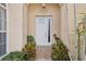Close-up of the front door with decorative glass and sidelight, framed by plants and stucco at 8024 Via Fiore, Sarasota, FL 34238