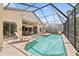 Private screened-in pool surrounded by lush greenery and serene backyard views for tranquil relaxation at 8024 Via Fiore, Sarasota, FL 34238